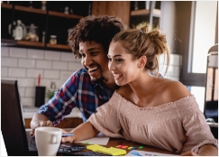 Una pareja usando una computadora portátil para aprender cómo comenzar a ahorrar